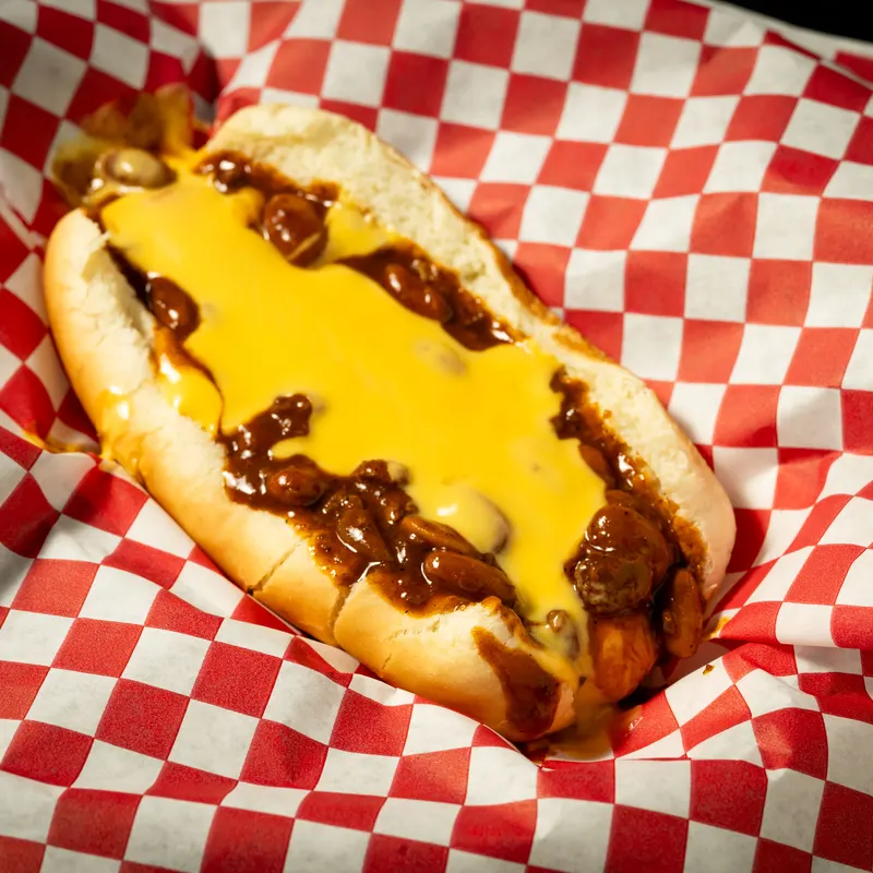 A chili cheese dog in a red-checkered basket