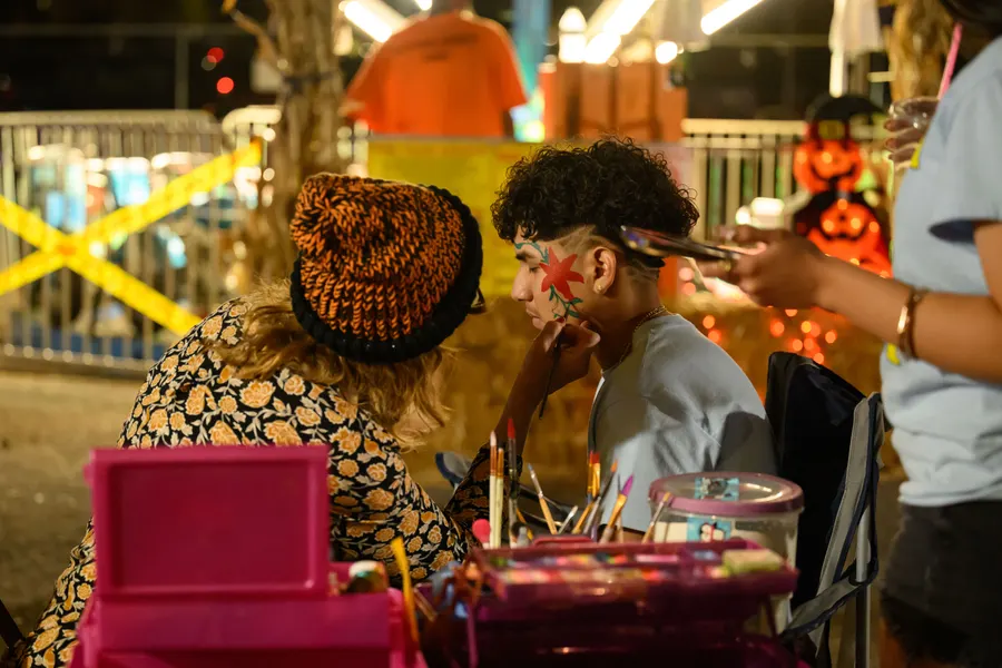 A face painter working on a young guest's cheek