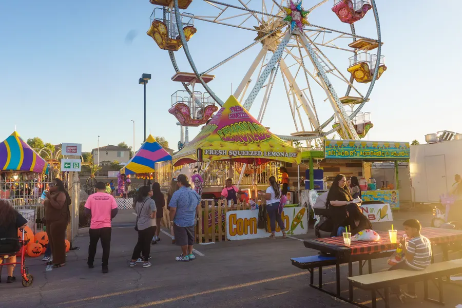 Families at the kids activity area with the Ferris wheel behind